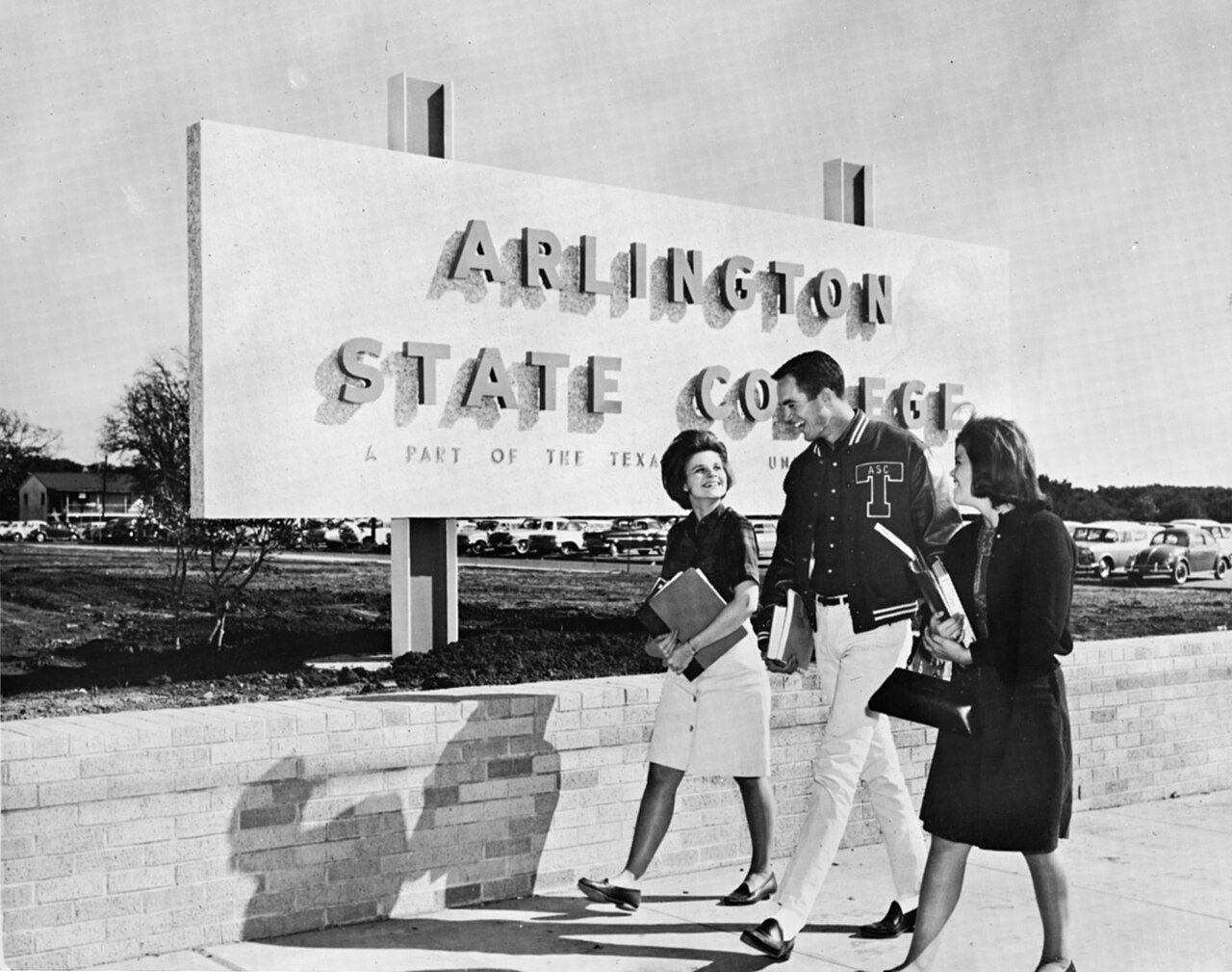 Three students walking in front of Arlington State College sign (10008778)